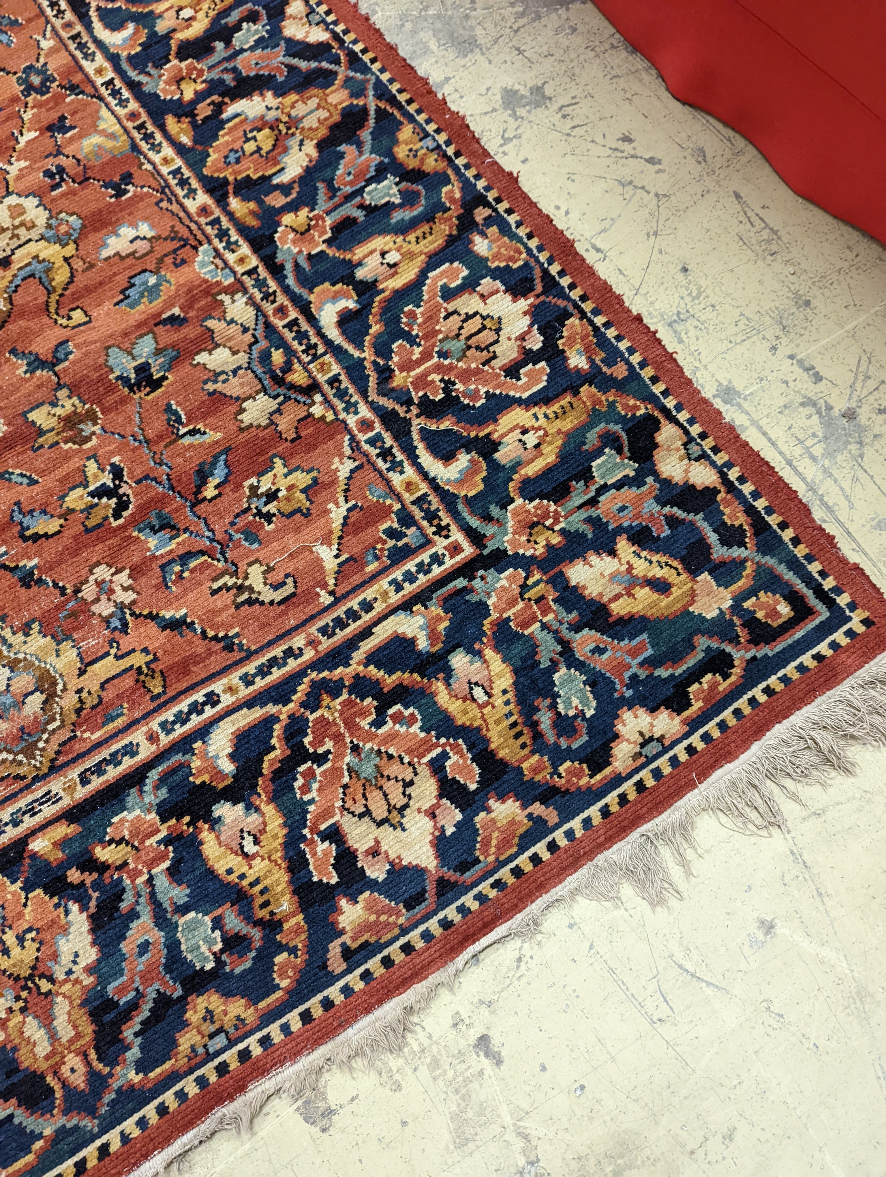 A Persian style machined brick red ground carpet (severely worn), 392 x 286cm
